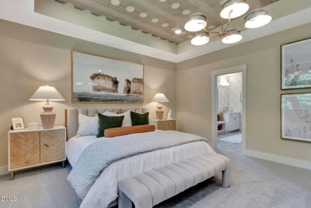 a bedroom with a large bed and a chandelier