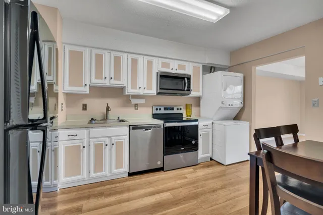 a kitchen with stainless steel appliances granite countertop a refrigerator a stove top oven a sink and dishwasher