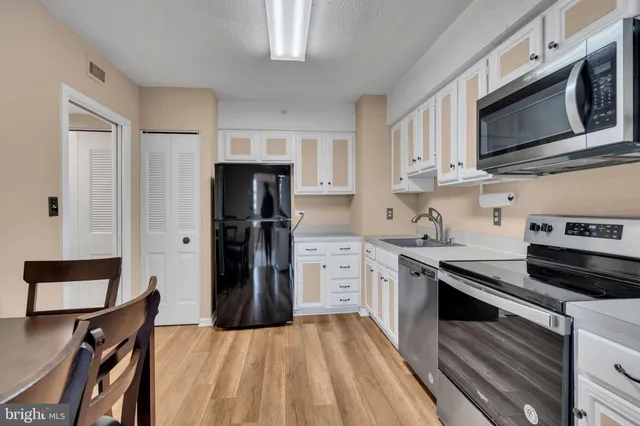 a kitchen with stainless steel appliances a stove microwave and sink