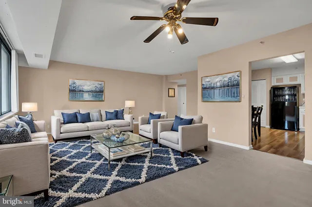an empty room with chandelier fan and windows