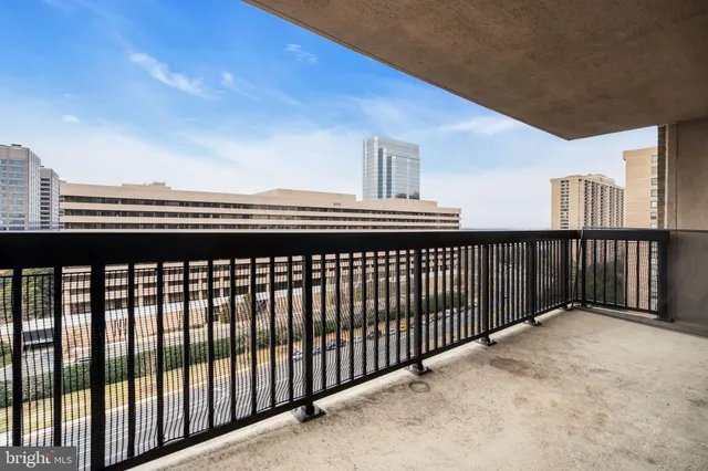 a view of a balcony with a couple of buildings in the background