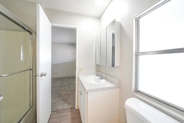 a bathroom with a double vanity sink toilet and shower