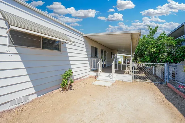 a view of a porch with chairs and potted plants