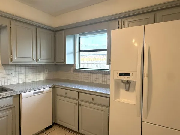 a kitchen with a white cabinets and a refrigerator