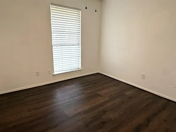 an empty room with wooden floor and a window