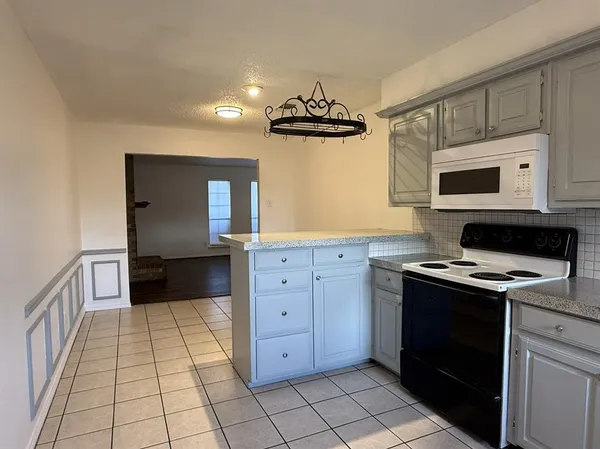 a kitchen with a refrigerator and a stove top oven