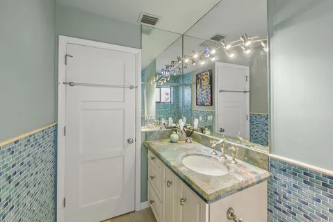 a bathroom with a sink vanity granite and a mirror