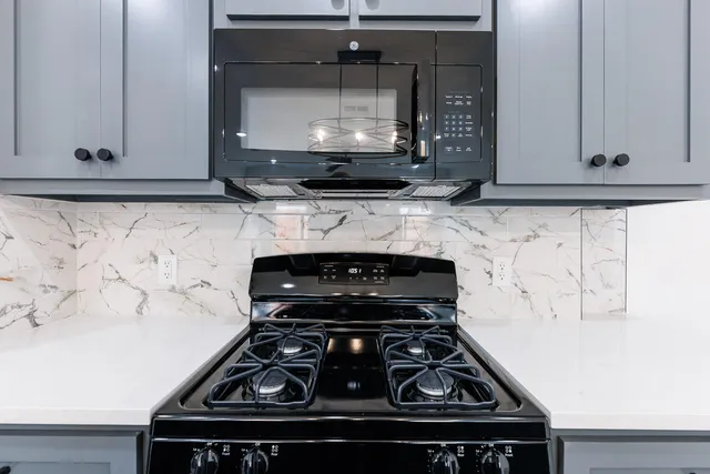 a stove top oven sitting inside of a kitchen