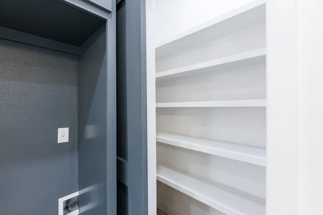 a view of walk in closet with empty racks