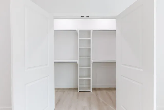 a view of walk in closet with empty racks
