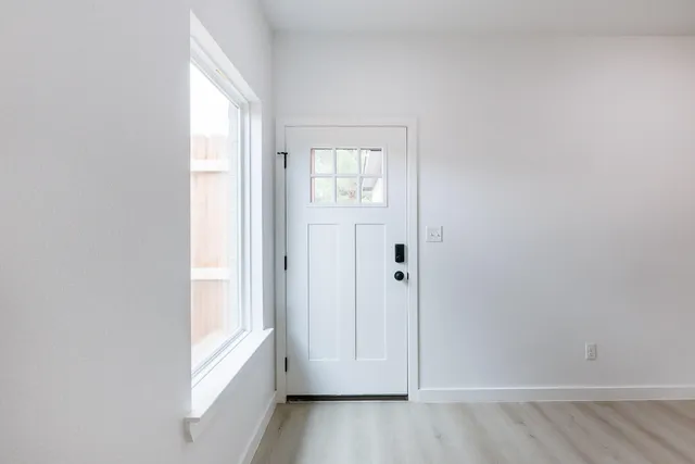 an empty room with wooden floor and windows
