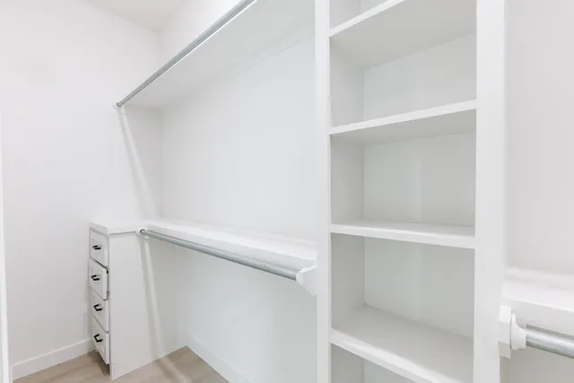a view of walk in closet with empty racks