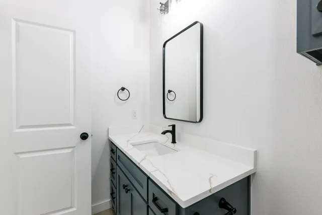 a bathroom with a sink vanity and a mirror