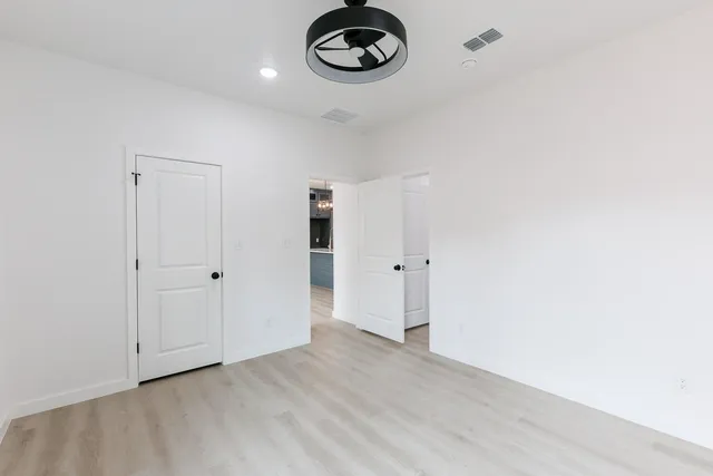 a view of a room with stainless steel appliances wooden floor and cabinets
