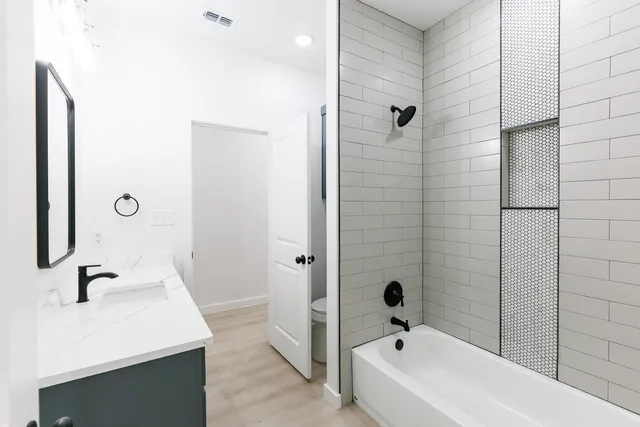 a bathroom with a tub sink a mirror and shower