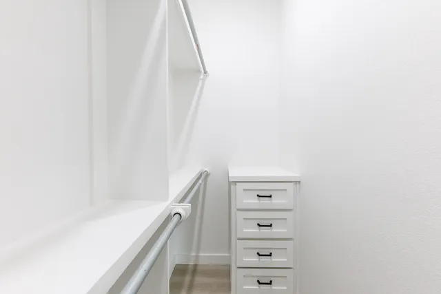 a view of walk in closet with empty racks