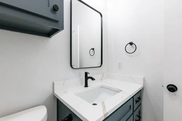 a bathroom with a sink toilet and mirror
