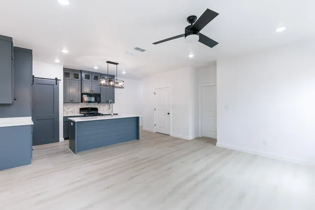a kitchen with stainless steel appliances kitchen island wooden cabinets and fireplace