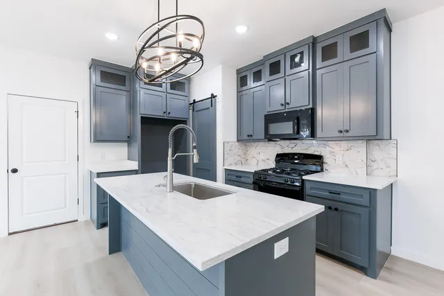 a kitchen with cabinets a sink and stainless steel appliances