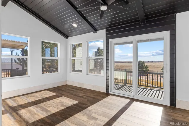 a view of a room with wooden floor and a balcony