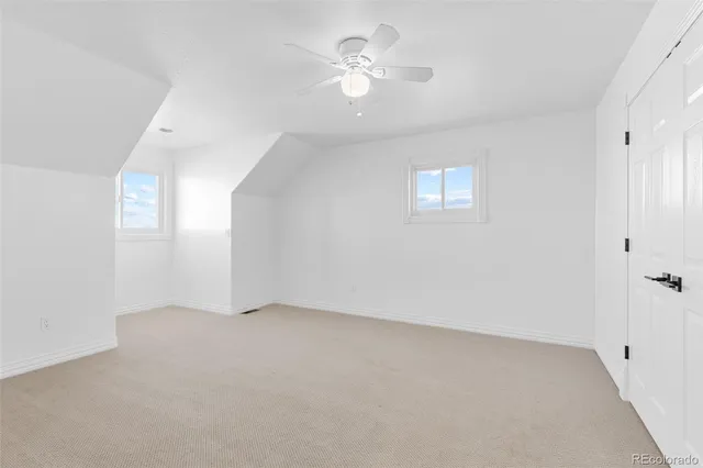 an empty room with fan and windows