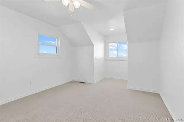 an empty room with a window and a ceiling fan