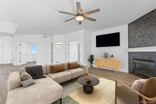 a living room with furniture a flat screen tv and a fireplace