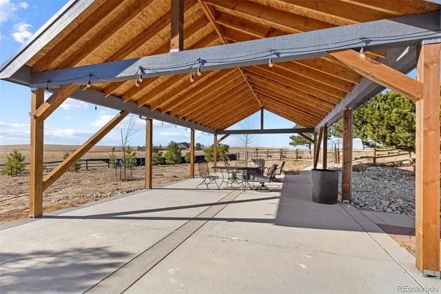 a view of a patio with table and chairs under an umbrella