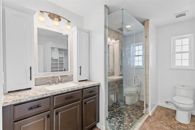 a bathroom with a granite countertop sink toilet and shower