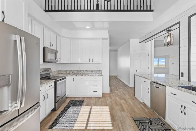 a kitchen with granite countertop a sink stove and refrigerator