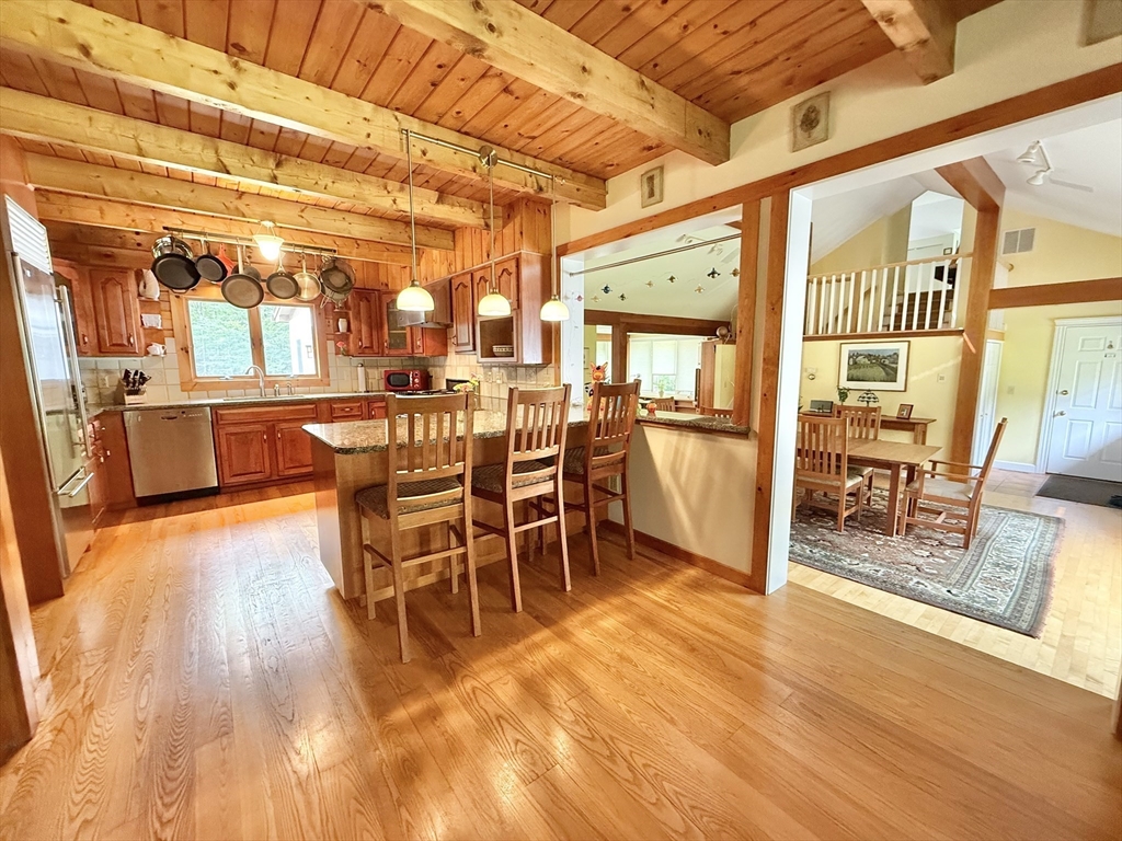 95 Ball Road Goshen, MA 01032 - Photo 10 of 33 a dining room with wooden floor a chandelier a glass table and chairs