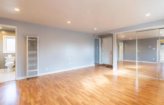 a view of empty room with wooden floor