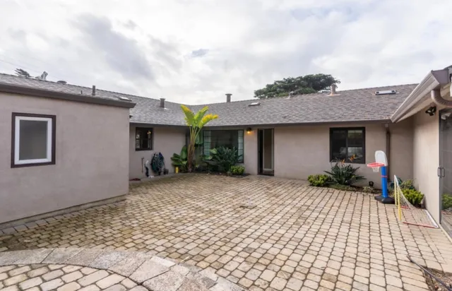 a front view of a house with a yard and potted plants