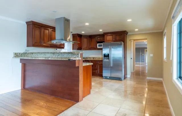 a kitchen with stainless steel appliances granite countertop a refrigerator and a sink