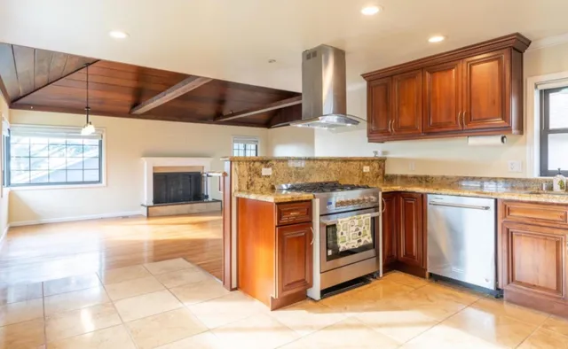 a kitchen with stainless steel appliances granite countertop a stove a sink and a microwave