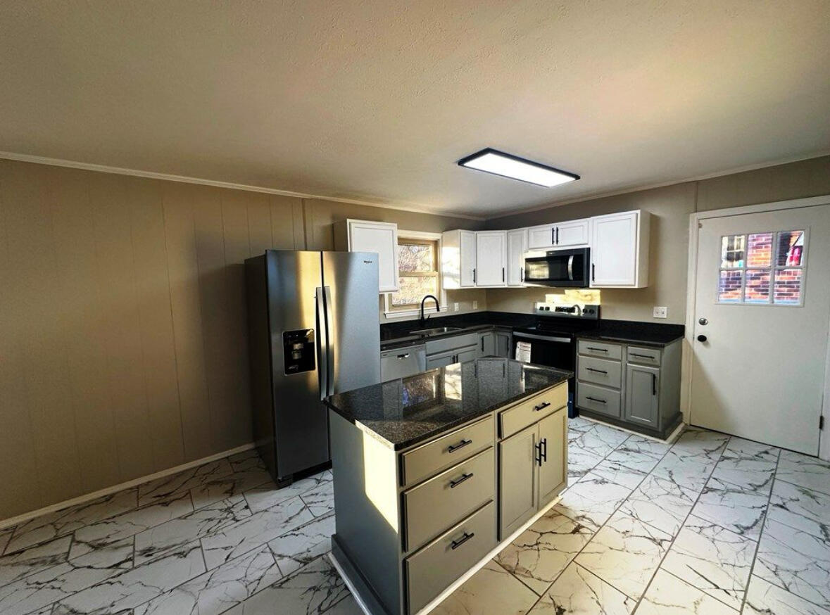 303 Swain Drive Danville, VA 24540 - Photo 8 of 24 a kitchen with granite countertop a sink and cabinets