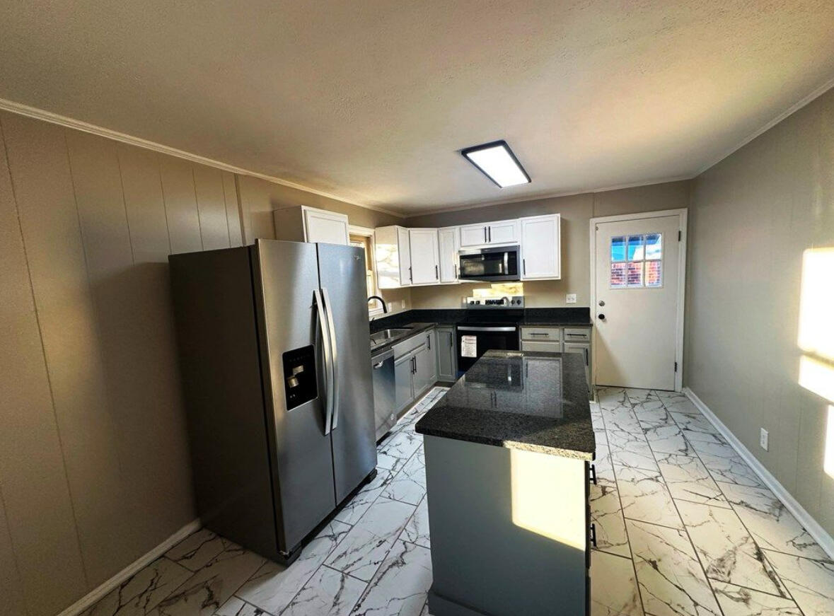 303 Swain Drive Danville, VA 24540 - Photo 9 of 24 a kitchen with granite countertop a refrigerator and a sink