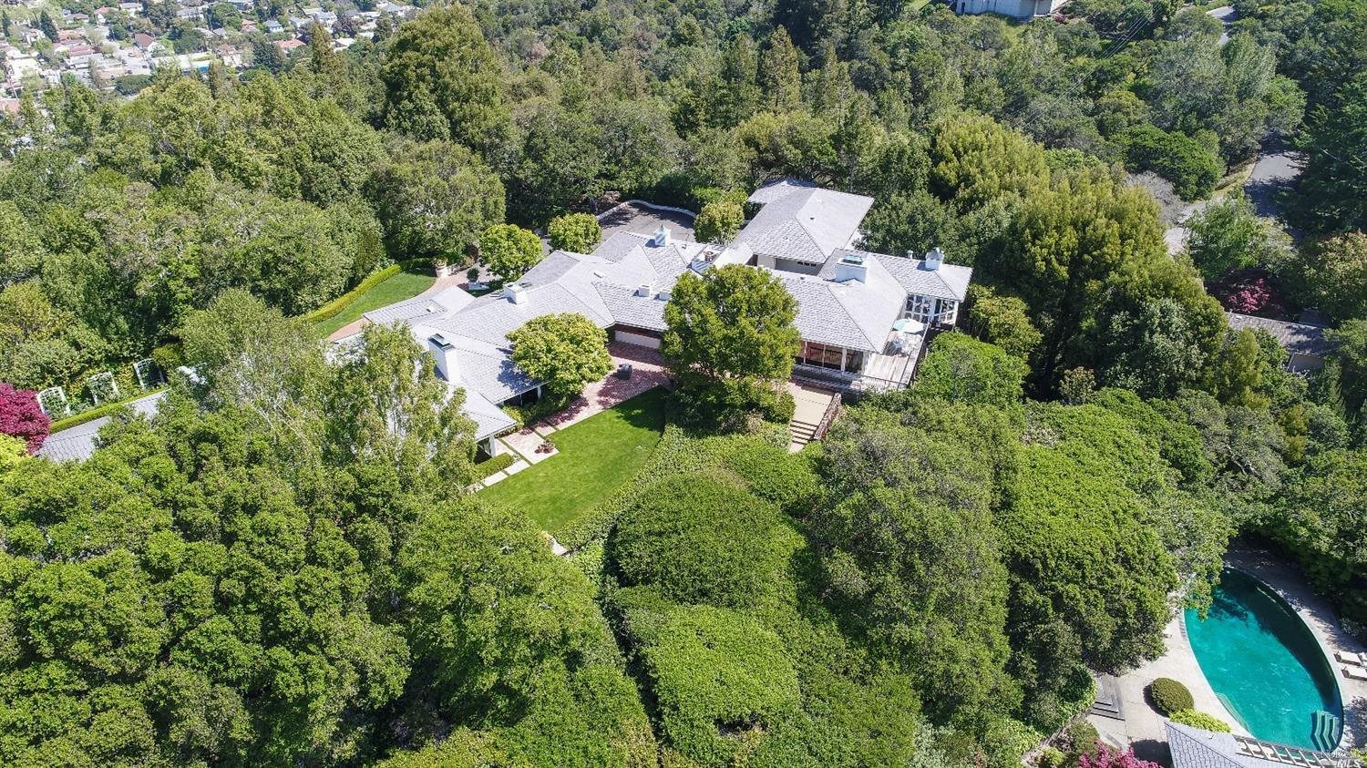 an aerial view of a house with lots of green space