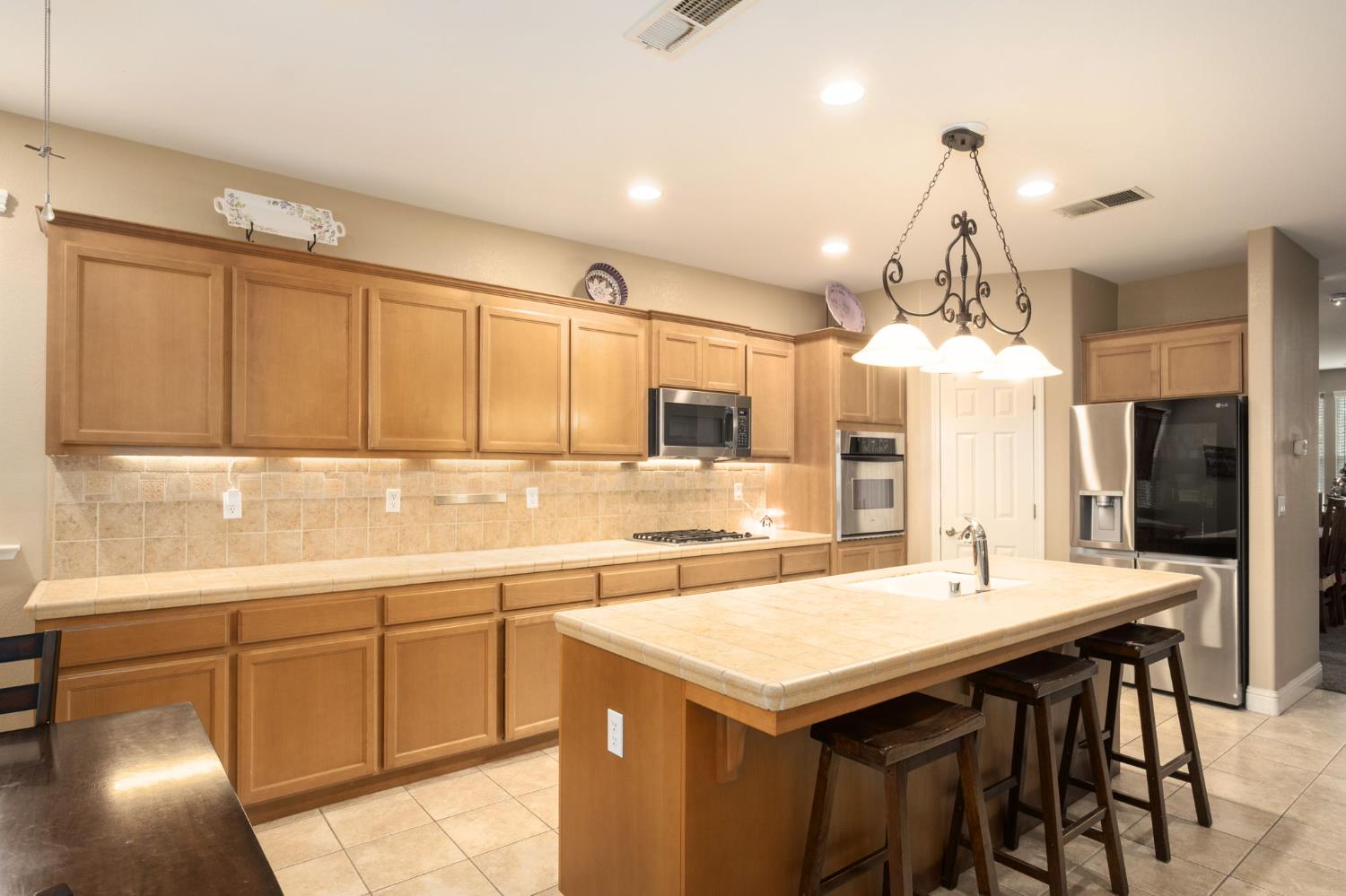 775 South Michelle Avenue Kerman, CA 93630 - Photo 14 of 37 a kitchen with a sink a center island and cabinets