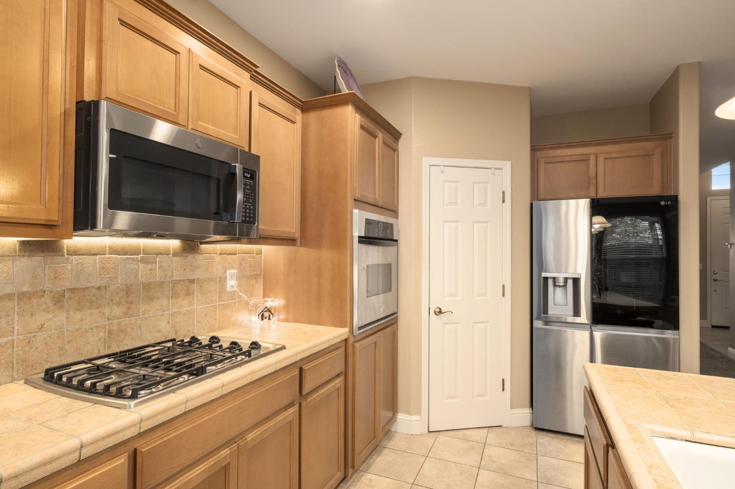 775 South Michelle Avenue Kerman, CA 93630 - Photo 15 of 37 a kitchen with stainless steel appliances a stove a microwave and a refrigerator
