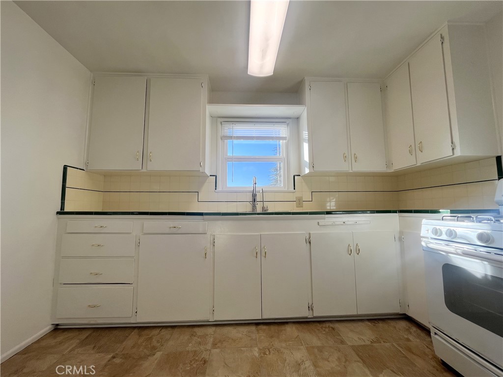 911 Park Avenue Calimesa, CA 92320 - Photo 8 of 19 a kitchen with granite countertop white cabinets and sink