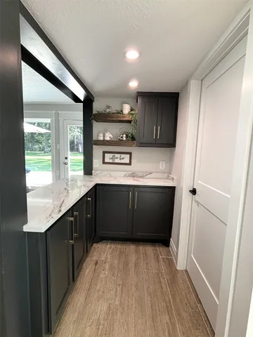 a kitchen with stainless steel appliances granite countertop a refrigerator a sink dishwasher a stove and white countertops with wooden floor