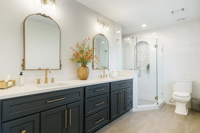 a bathroom with a double vanity sink toilet and a mirror