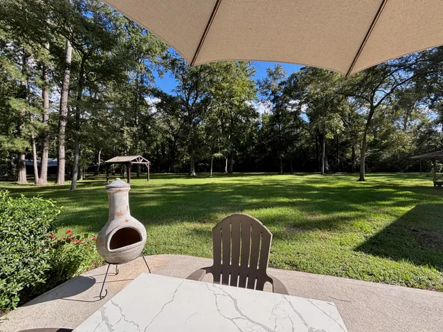 a swimming pool with barbeque oven outdoor seating and yard