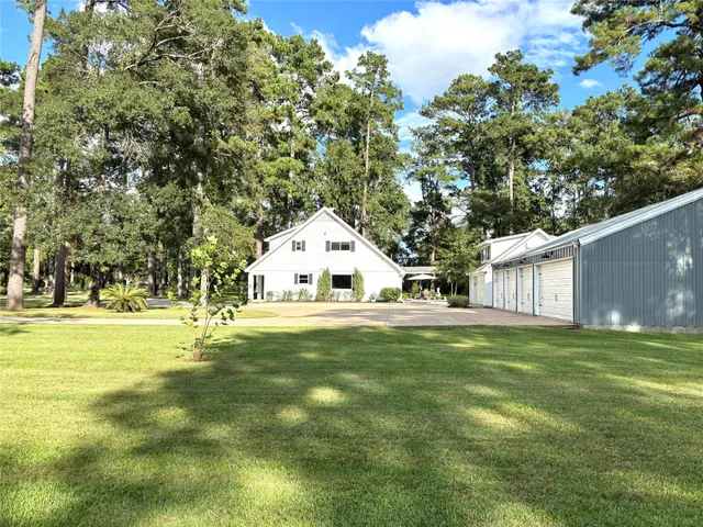a view of a trees and barn in the middle of a yard