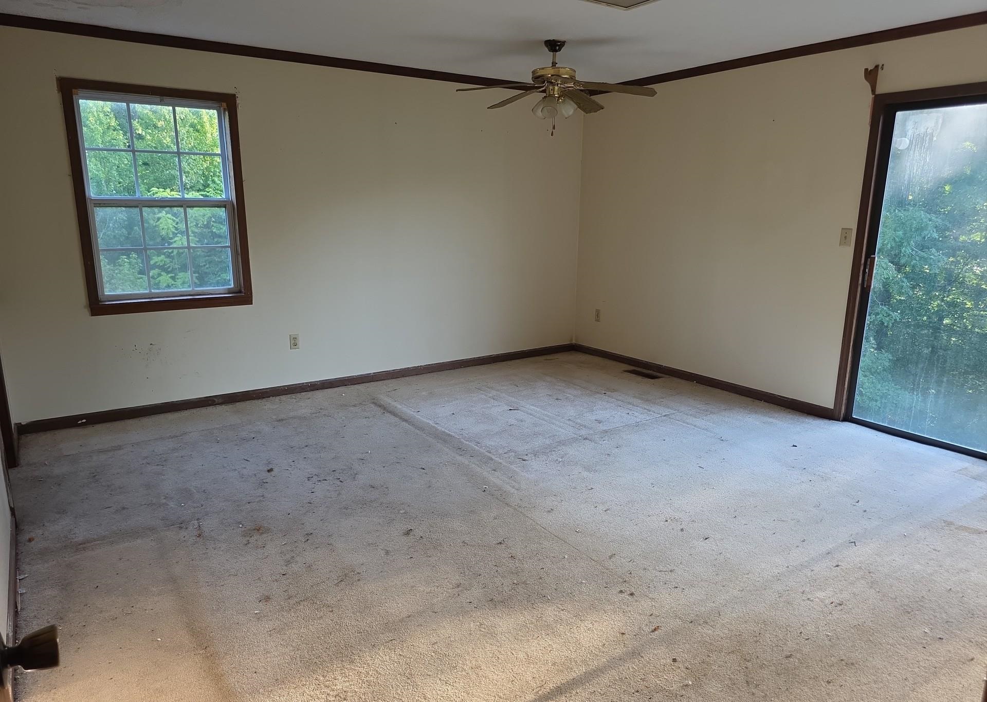 5646 Ramer Selmer Road Selmer, TN 38375 - Photo 11 of 20 Spacious room featuring a large window, sliding glass door, and ceiling fan