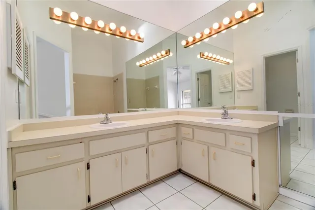 a spacious bathroom with a double vanity sink a mirror and a shower