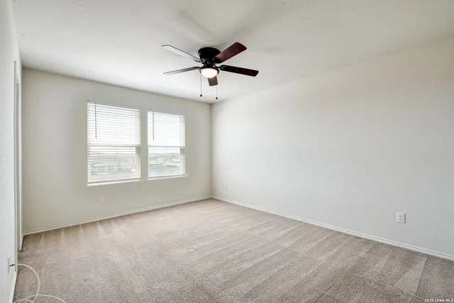 a view of empty room with ceiling fan