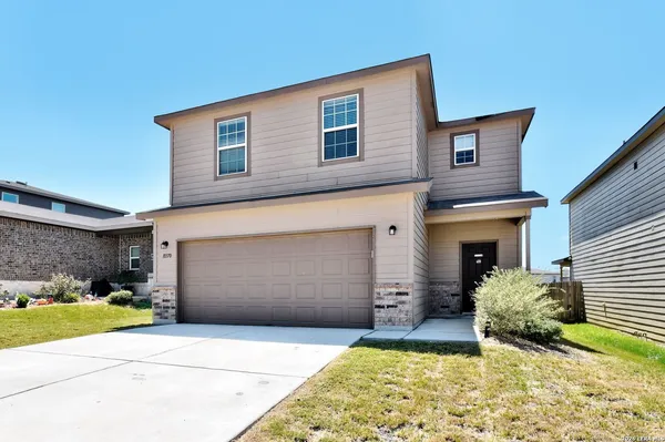 a front view of a house with a yard and garage