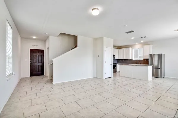 a kitchen with white cabinets and refrigerator